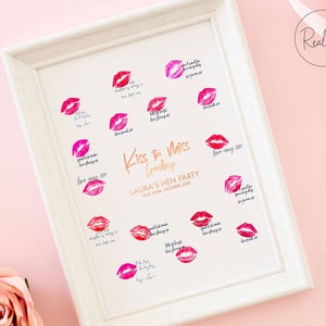 以下が含まれることがあります： ピンクの背景に白い額縁で飾られたプリント。金色の文字で「Kiss the Miss Goodbye」と書かれている。プリントには唇のプリントのデザインと「Laura's Hen Party, New York, October 2020」というテキストが書かれている。