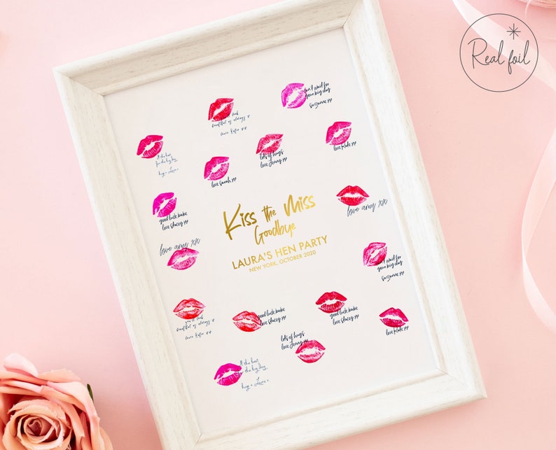以下が含まれることがあります： 「Kiss the Miss Goodbye」と「Laura's Hen Party, New York, October 2020」という金色の文字が書かれた白い額縁付きのプリント。プリントは白い背景に赤い口紅のキス跡と手書きのメッセージが書かれている。