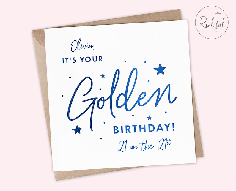 May include: A white card with blue foil lettering that says "Olivia, It's your Golden Birthday! 21 on the 21st". The card has a brown envelope.