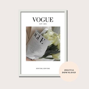 May include: A white framed print with the text "VOGUE EST. 1892 NEW YORK, NEW YORK" and a photo of a bouquet of white tulips wrapped in a Vogue magazine.