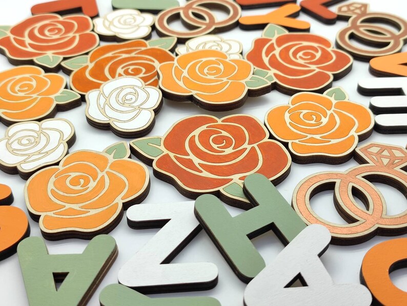 May include: Wooden craft supplies featuring orange and white roses, green leaves, and letters in white, green, and brown. The letters spell out the word "ZACHARY".