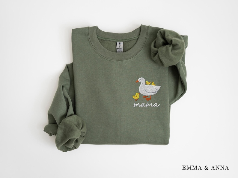 May include: A green sweatshirt with an embroidered design of a goose with goslings and the word "mama" underneath.
