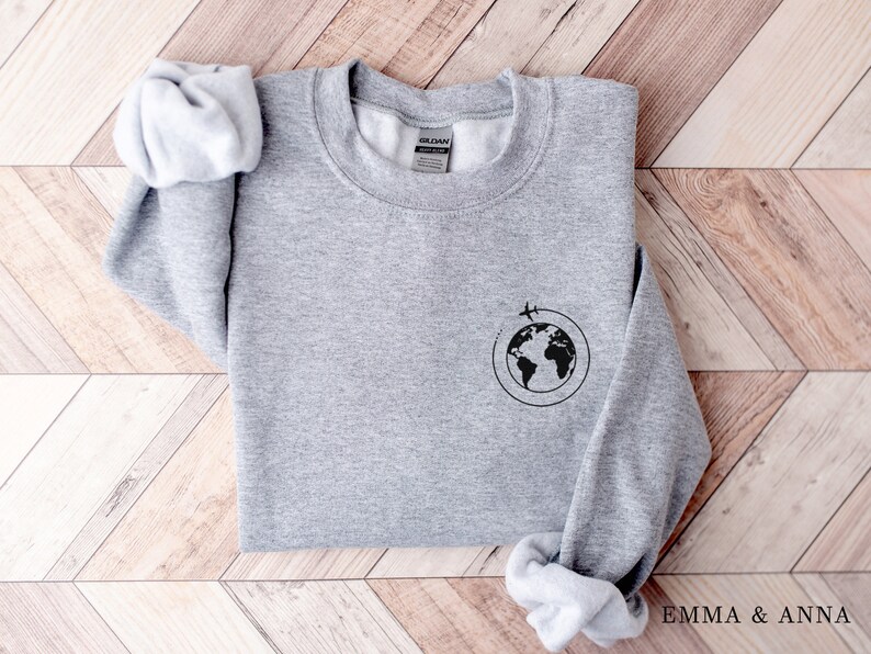 May include: Gray sweatshirt with a black graphic of a globe with airplanes flying around it.