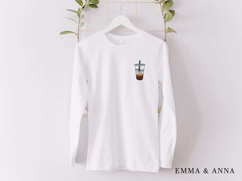 Peut inclure: T-shirt &agrave; manches longues blanc avec un graphique d'un caf&eacute; glac&eacute; sur le devant.