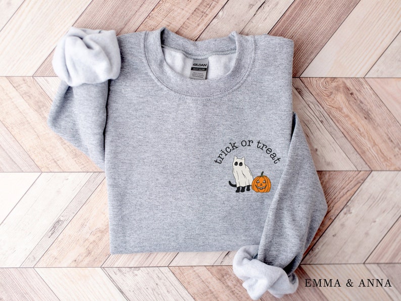 May include: Gray sweatshirt with a white ghost and orange pumpkin graphic and the text "trick or treat".