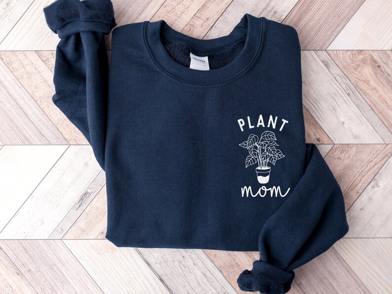 May include: A navy blue sweatshirt with a white graphic of a potted plant and the text "PLANT MOM".