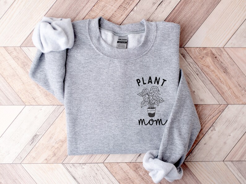 May include: Gray sweatshirt with the text "PLANT MOM" and a simple line drawing of a potted plant.
