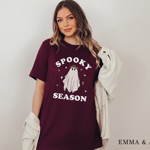 May include: A maroon t-shirt with a white ghost graphic and the text "Spooky Season".