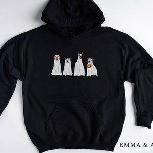 May include: Black hoodie featuring a graphic of four dogs dressed as ghosts. The dogs are wearing white sheets with their heads poking out. The text "EMMA & ANNA" is printed on the bottom right corner of the hoodie.