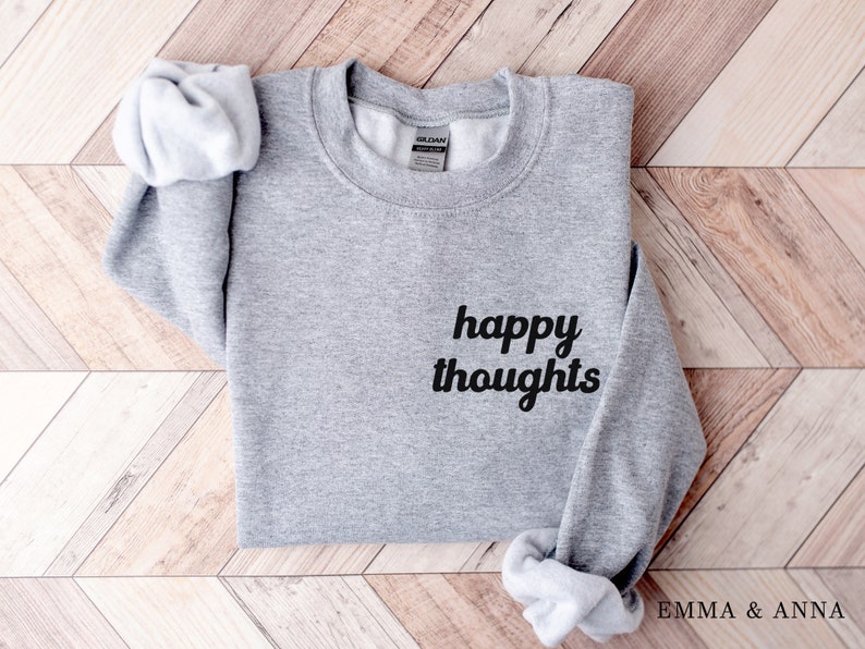 May include: Gray sweatshirt with the text "happy thoughts" in black cursive lettering.