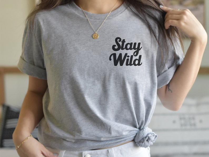 May include: A gray t-shirt with the text "Stay Wild" in black, stylized lettering.