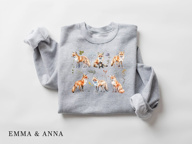 May include: A gray sweatshirt with a print of multiple orange foxes surrounded by flowers and leaves.