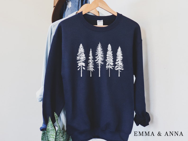 May include: A navy blue sweatshirt with a white graphic of five pine trees. The sweatshirt has a crew neck and long sleeves.