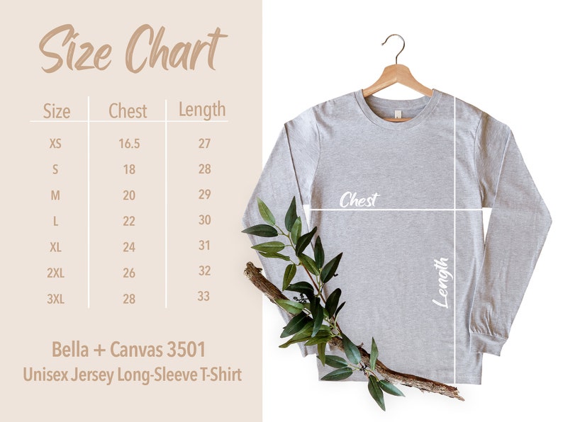 May include: Size chart for a unisex long-sleeve t-shirt, showing chest and length measurements in inches for sizes XS to 3XL. The chart is printed on a beige background with a gray t-shirt hanging on a wooden hanger. The t-shirt is on a white background with a green branch.