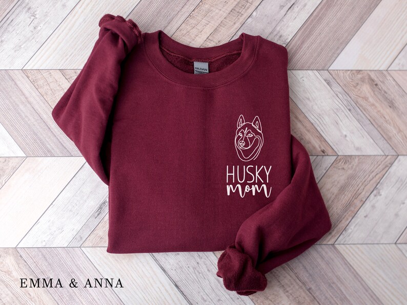 Pode incluir: Camisola de cor bord&ocirc; com um contorno branco de um c&atilde;o husky e o texto "Husky Mom" na frente.