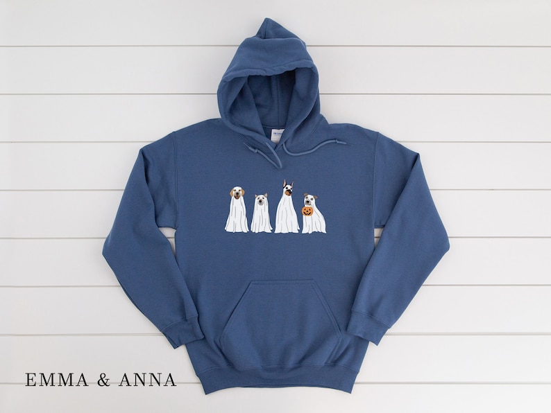 May include: A blue hooded sweatshirt featuring a graphic of four dogs dressed as ghosts for Halloween. The dogs are a Labrador Retriever, a Jack Russell Terrier, a Doberman Pinscher, and a Beagle.