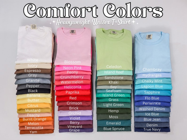 May include: A display of 24 different colored t-shirts stacked in rows of four. The t-shirts are all the same style, a heavyweight unisex t-shirt. The colors are arranged in three columns, with each column representing a different color family: white, pink, green, blue. The colors are labeled with their names, such as "White", "Ivory", "Espresso", "Gray", "Granite", "Pepper", "Black", "Banana", "Butter", "Citrus", "Mustard", "Peachy", "Burnt Orange", "Melon", "Terracotta", "Yam", "Blossom", "Neon Pink", "Peony", "Crunchberry", "Watermelon", "Heliconia", "Paprika", "Red", "Crimson", "Brick", "Orchid", "Violet", "Berry", "Vineyard", "Grape", "Celedon", "Island Reef", "Sandstone", "Khaki", "Bay", "Seafoam", "Island Green", "Grass", "Light Green", "Hemp", "Moss", "Emerald", "Blue Spruce", "Chambray", "Hydrangea", "Chalky Mint", "Lagoon Blue", "Sapphire", "Flo Blue", "Periwinkle", "Washed Denim", "Ice Blue", "Blue Jean", "Denim", "True Navy".