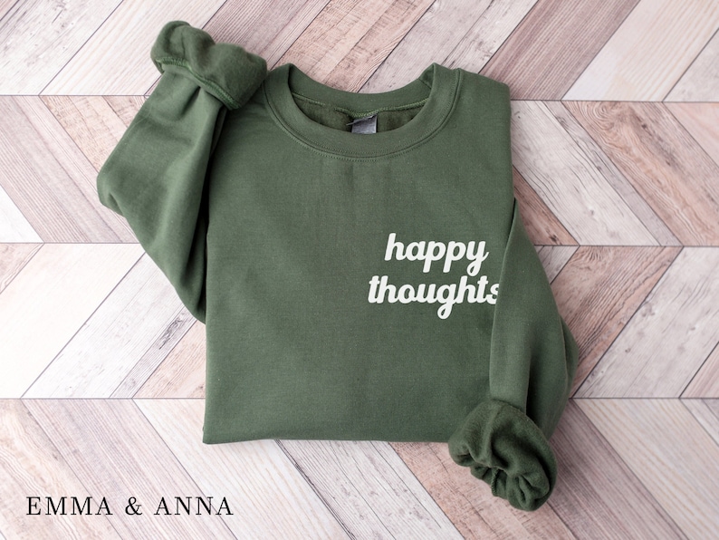 May include: A green sweatshirt with the text "happy thoughts" in white on the front.