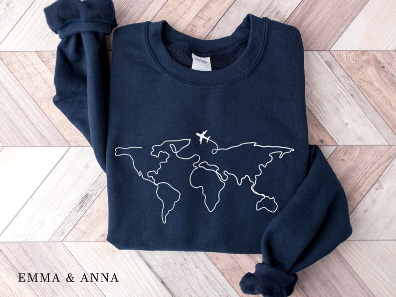 May include: A navy blue sweatshirt with a white outline of a world map and a small airplane above it.