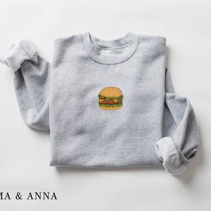 May include: A gray sweatshirt with a cartoon drawing of a hamburger on the front.
