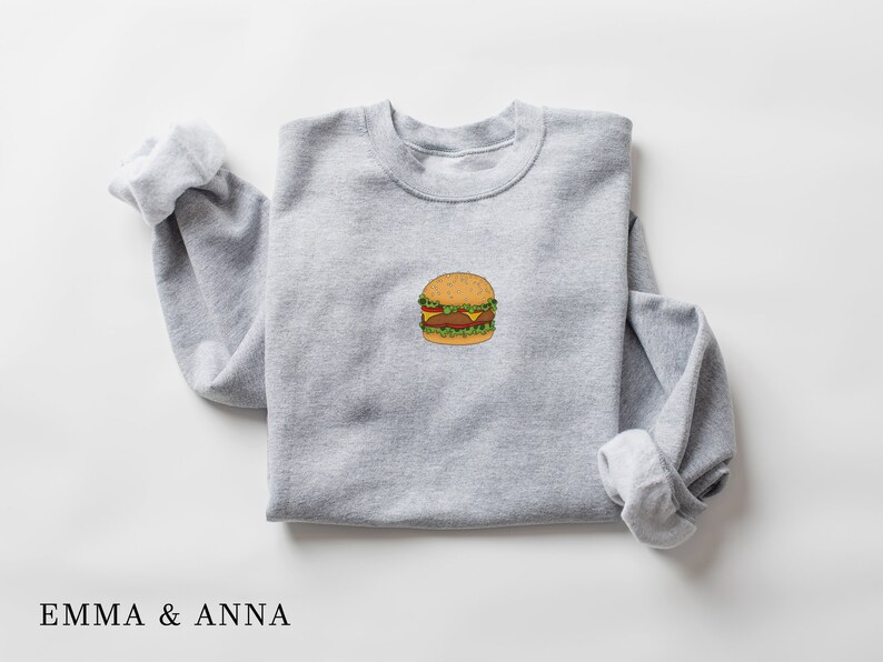 May include: A gray sweatshirt with a cartoon drawing of a hamburger on the front.