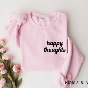 May include: Pink sweatshirt with the text "happy thoughts" in black lettering.