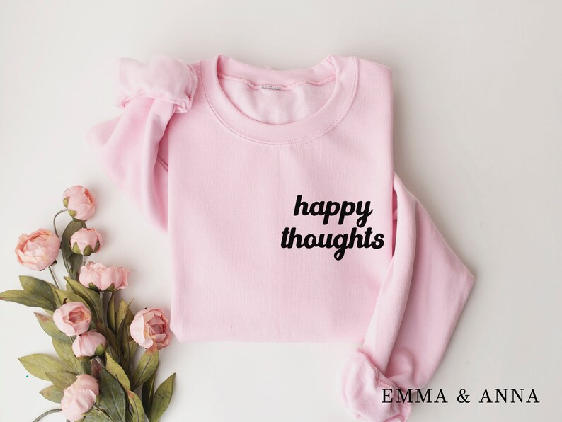 May include: Pink sweatshirt with the text "happy thoughts" in black lettering.