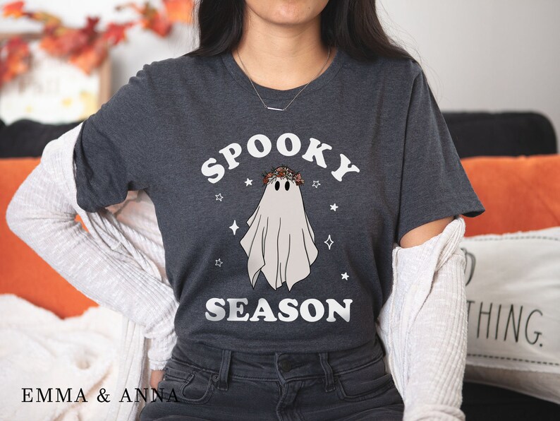 May include: A dark gray t-shirt with a white ghost wearing a floral crown and the text "Spooky Season".