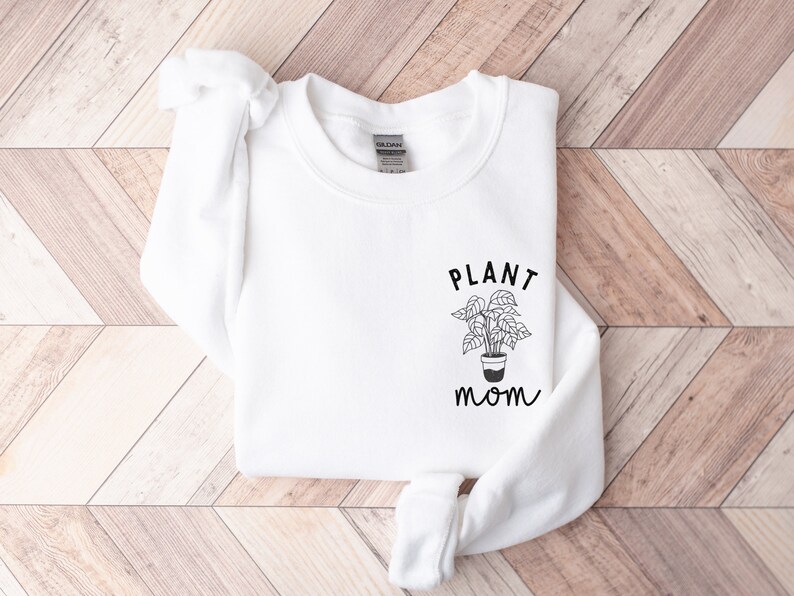 May include: White sweatshirt with the text "PLANT mom" and a simple line drawing of a potted plant.