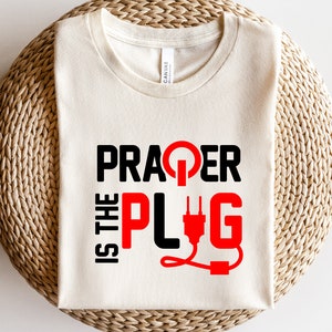 May include: A white t-shirt with black text that reads "Prager is the Plug" with a red plug graphic.