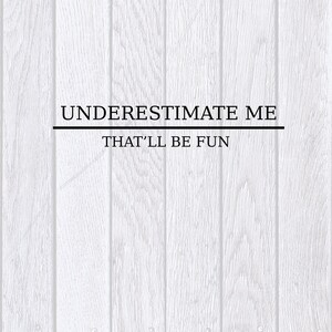 May include: White wood panel background with black text that reads "UNDERESTIMATE ME THAT'LL BE FUN"