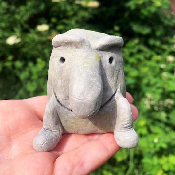 A hand-sculpted clay oddity with a goofy oversized nose and friendly strange face — pure Irish folk-art charm that belongs on a shelf of curiosities.