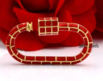 May include: Red enamel and gold-toned metal lobster clasp. The clasp is oval shaped and has a textured surface. The clasp is a popular accessory for necklaces, bracelets, and keychains.