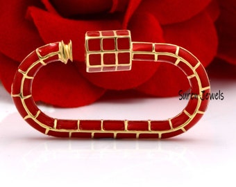 May include: Red enamel and gold-toned metal clasp with a square-shaped design. The clasp is in the shape of an oval.