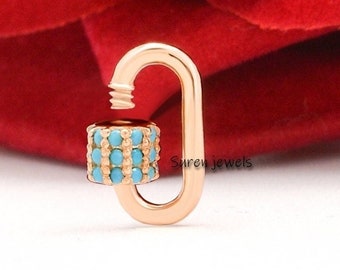 May include: A rose gold lobster clasp with a turquoise stone accent. The clasp is a popular jewelry finding for necklaces and bracelets.