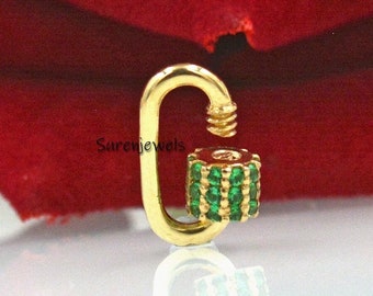 May include: Gold charm featuring a green emerald stone design. The charm is shaped like a carabiner clip.