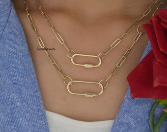 May include: A gold chain necklace with two oval-shaped clasps. The necklace is layered and features a delicate chain design.