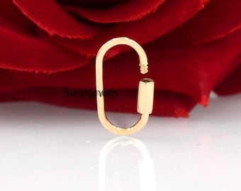 May include: Gold-toned oval-shaped clasp with a spring-loaded closure. The clasp is designed to attach to a chain or other jewelry.