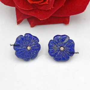 May include: A pair of blue lapis lazuli flower earrings with a small diamond in the center of each flower.
