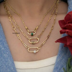 May include: Three gold chain necklaces with different coloured gemstone accents. The necklaces feature a unique clasp design.