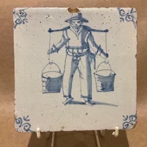 17th century Delft tile of a man with a yoke and 2 pails of water or milk, circa 1660