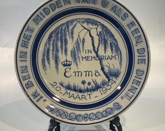 May include: A blue and white ceramic plate with a weeping willow tree design and the text "IK BEN IN HET MIDDEN VAN U AL EEN, DIE DIENT" around the edge. The center of the plate features a crown, the name "Emma", and the dates "20-MAART - 1934" in blue lettering. The text "IN MEMORIAM" is also included.