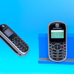 Peut inclure: Deux téléphones portables Motorola sur fond bleu. L'un est incliné à gauche, l'autre est droit dans un support bleu. Les deux téléphones sont noirs et argentés avec un clavier et un écran. Le logo Motorola est visible.