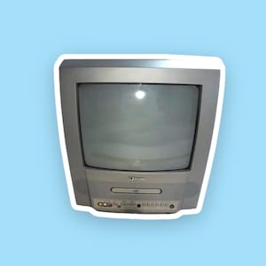 Könnte beinhalten: Ein silberfarbener Vintage-Fernseher mit eingebautem DVD-Player. Der Fernseher hat einen rechteckigen Bildschirm und einen Lautsprecher auf jeder Seite. Der DVD-Player befindet sich unter dem Bildschirm.