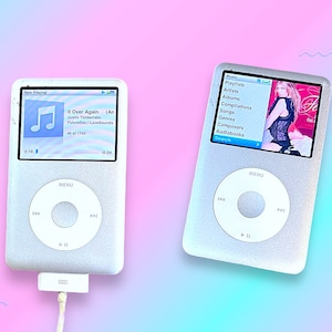 Op de afbeelding: Twee zilveren iPods worden getoond tegen een roze en blauwe gradiënt achtergrond. Eén toont een muzieknummer getiteld "II Over Again" van Justin Timberlake. De andere iPod toont een muziekmenu met opties als "Playlists" en "Artiesten".