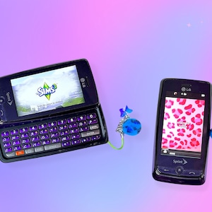 Könnte beinhalten: Zwei schwarze LG Sprint-Telefone. Eines ist geöffnet und zeigt das Spiel Sims 3 und eine Tastatur. Das andere zeigt einen rosa Leopardenmuster. Blaue Anhänger hängen an den Telefonen. Der Hintergrund ist ein Farbverlauf.