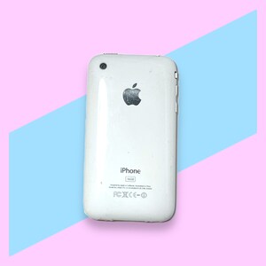 May include: A white iPhone 16GB model, viewed from the back, featuring the Apple logo. The phone has a glossy finish and is set against a pink and blue geometric background.
