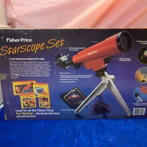 May include: A Fisher-Price Starscope Set, a real telescope for kids, is displayed. The red telescope sits on a white tripod. The box features the product name, images of space, and text that reads "Look for all the Fisher-Price Fun Starters...because learning should be fun!"