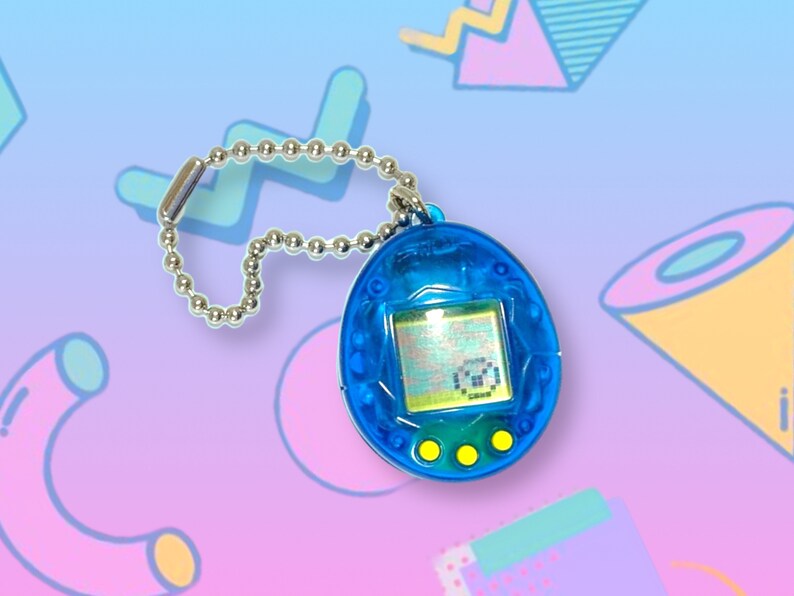 May include: A blue handheld digital pet game with a silver chain. The egg-shaped device has a small screen displaying pixelated graphics and three yellow buttons below. The background features a colorful, retro-style design.