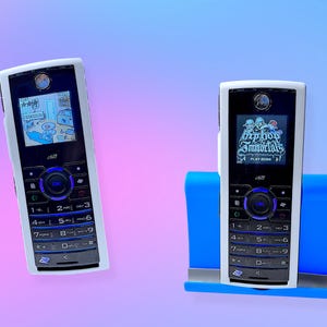 Peut inclure: Deux téléphones portables blancs et noirs avec des détails bleus et des écrans affichant des graphiques. Un téléphone est dans un support bleu. L'autre téléphone est couché. Le fond est un dégradé rose et bleu.